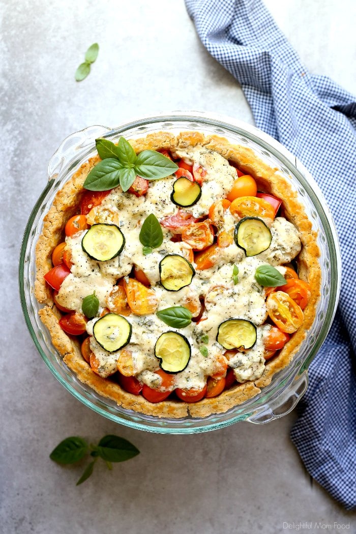 A mouthwatering gluten-free tomato zucchini pie made with fresh tomatoes, zucchini and basil with a warm goat cheese coating on top. It highlights summer’s best produce and is so versatile, ready to serve for brunch, lunch or dinner. #tomatozucchinipie #glutenfree #dinnerpie #tomatorecipes #recipe #zucchini #easy #dinner #healthy #summersquash #brunch #goatcheese #pie #glutenfreepies #summer | Recipe at Delightful Mom Food