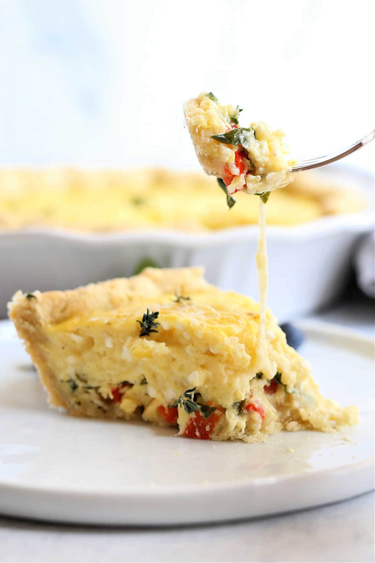 slice of breakfast quiche scooped with a fork
