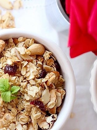 Bowl of basic granola with dried cranberries stirred in.