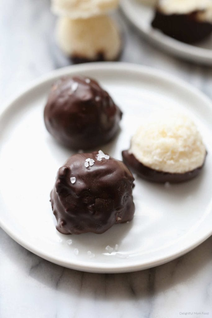 easy homemade mounds bar coconut balls with a chocolate coating on a white plate