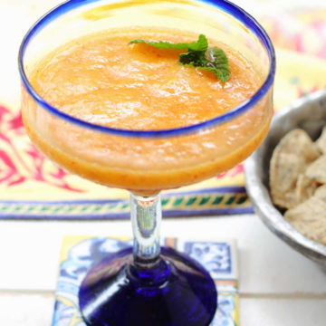 whole fruit Mexican peach margarita made with honey and tequila in a margarita glass on a coaster