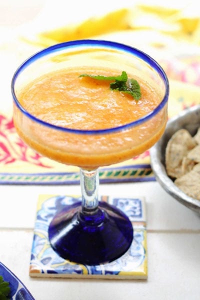 whole fruit Mexican peach margarita made with honey and tequila in a margarita glass on a coaster