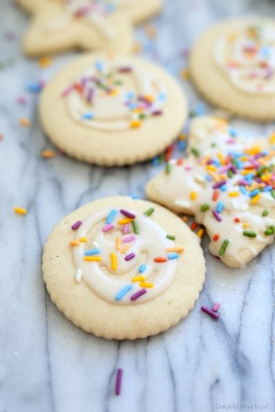 cut out gluten free sugar cookies decorated with white icing and rainbow sprinkles
