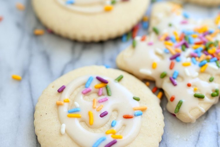 cut out gluten free sugar cookies decorated with white icing and rainbow sprinkles