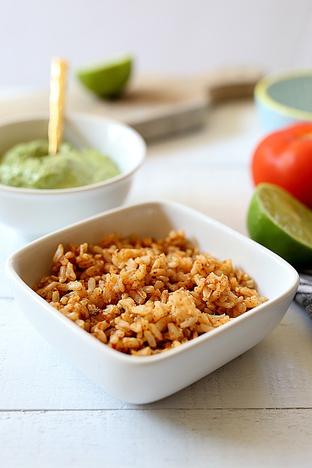 Spanish rice, beans, cheese, lettuce, cilantro and tomatoes stuffed into hard shell tacos and topped with a creamy green vegan sauce. Super easy and healthy recipe for hard shell tacos in under 30 minutes