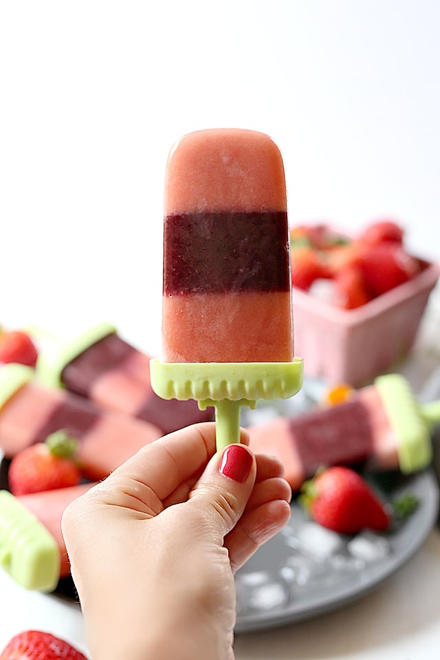 Strawberry popsicles are packed with blueberries, kale, yellow squash and nutritious almond milk! Enjoy these fruit and veggie ice pops as a smoothie or turned into popsicles! 