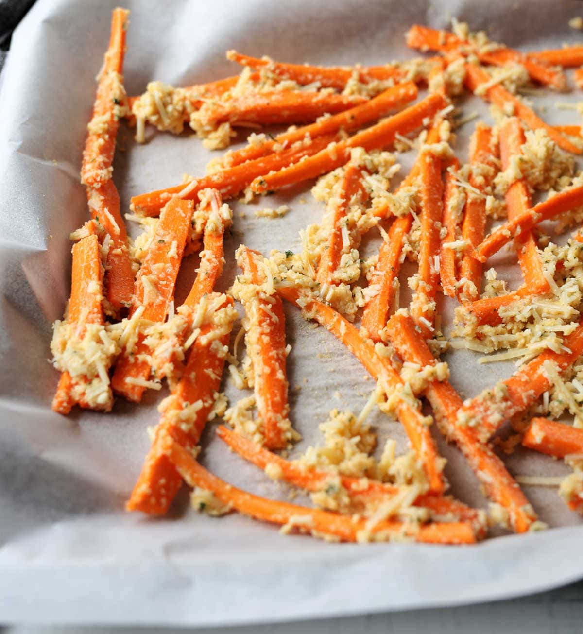 Baked Parmesan Carrot Fries prepared on a baking sheet lined with parchment paper