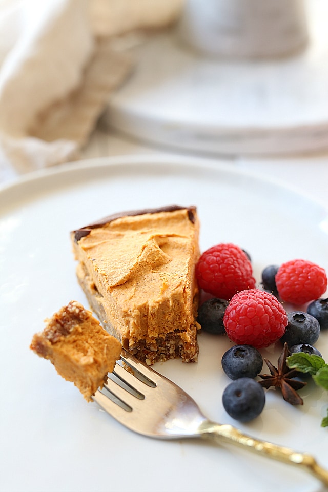 Fluffy vegan no bake pumpkin pie made with a raw date and nut base and coconut cool whip! A delicious delicate dessert served either partially frozen or soft and fluffy!