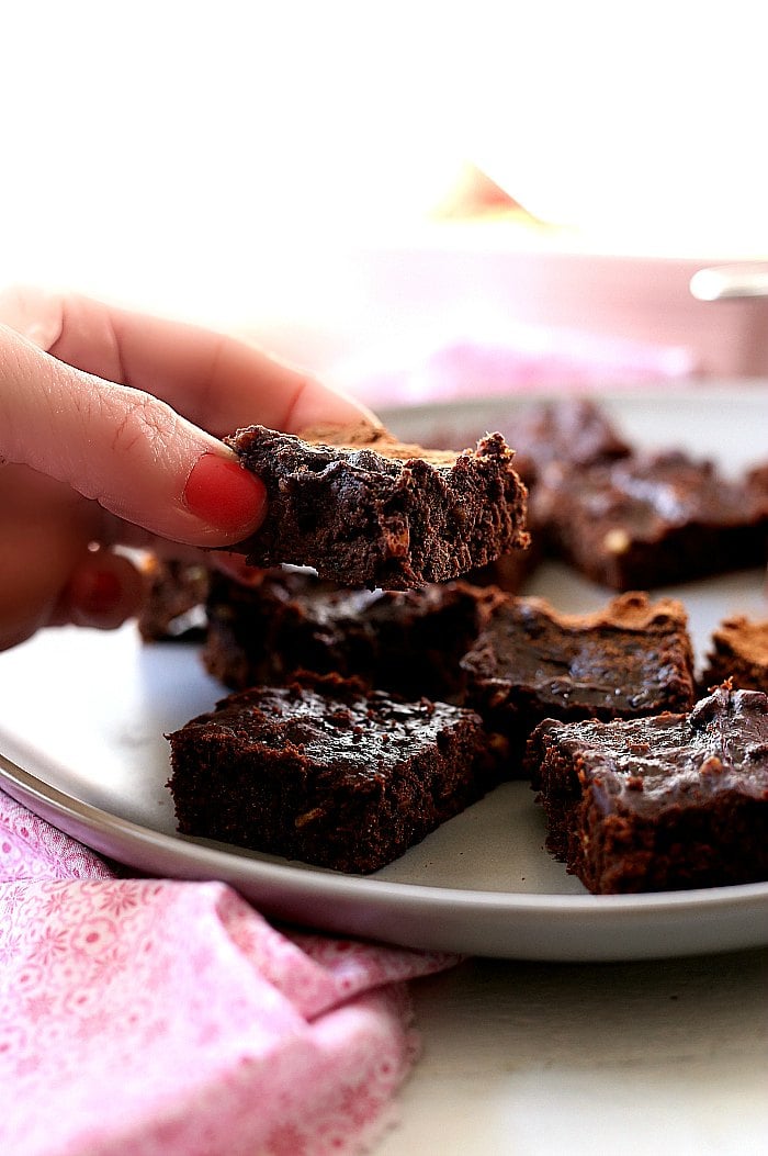 hand grabbing a 3 ingredient whole30 brownie off a plate