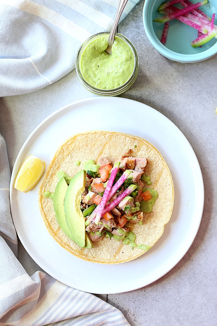 Slow cooker pork tacos slowly cooked in, and then drizzled with zesty green goddess dressing. An easy dinner and meal-prep with left overs that can serve another meal! #slowcooker #crockpot #pork #tacos #healthy #glutenfree #recipe #easy #dressing | delightfulmomfood.com