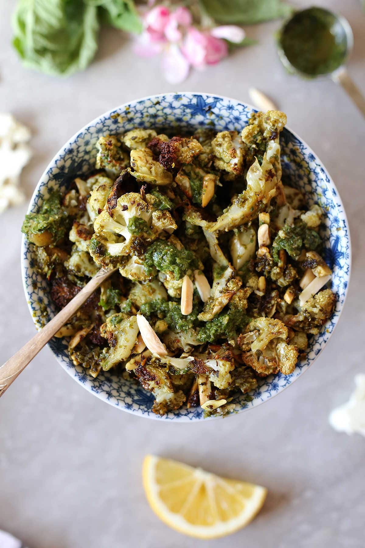 Roasted Cauliflower tossed with fragrant almond pesto and topped with crunchy toasted almond slivers will be your new favorite side dish! It is plant based, nourishing and made with vegan gluten-free ingredients. #sheetpan #easy #healthy #cauliflower #pesto #roasted #recipe #side #healthy | delightfulmomfood.com