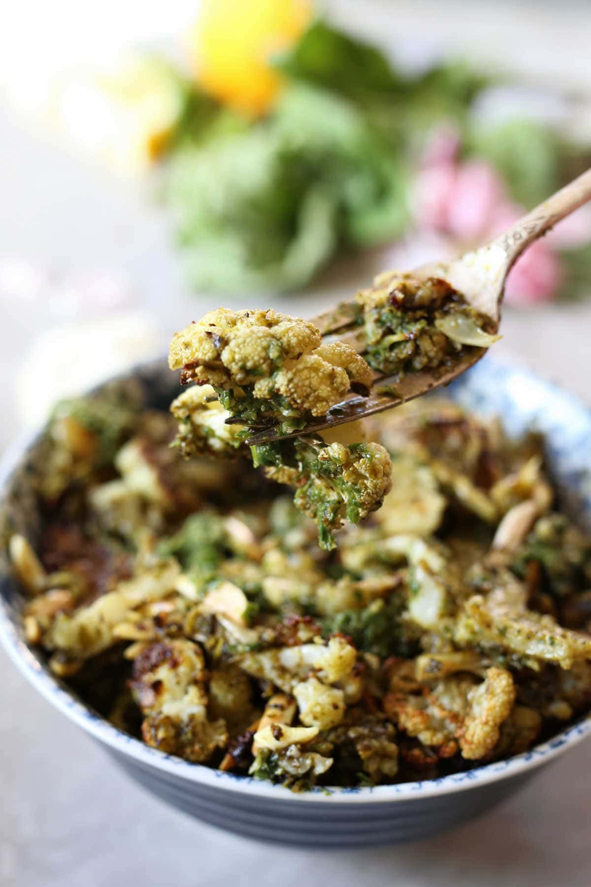 cauliflower roasted and tossed with pesto and almond slivers on a fork