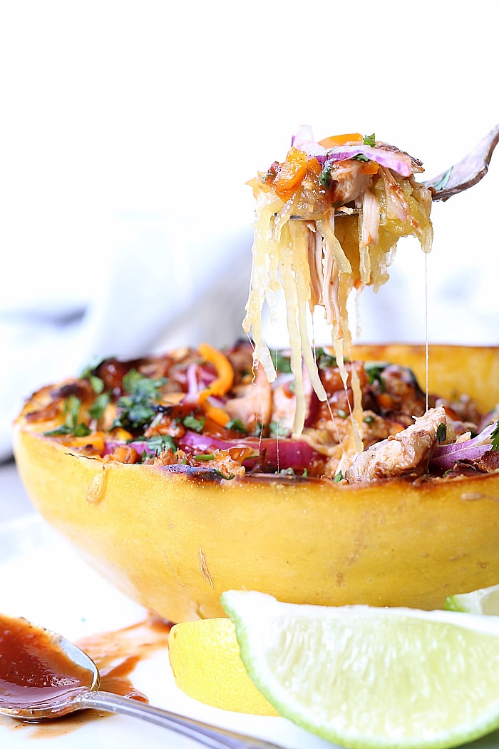 Barbecue chicken stuffed spaghetti squash boats are so easy to make, especially if you cook the shredded chicken in the slow cooker! It is a delicious light and hearty gluten-free spaghetti squash recipe you can feel lean about eating! #bbq #chicken #spaghetti #squash #recipe #boats #easy #healthy | delightfulmomfood.com