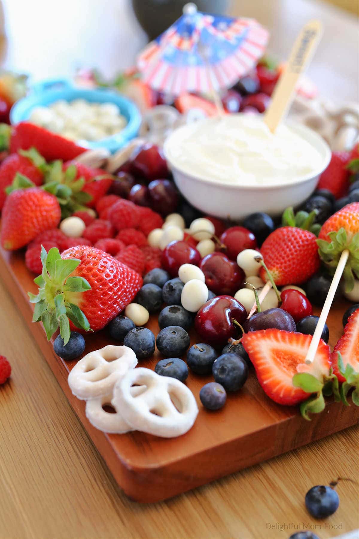 Red White and Blue Fruit platter presentation Ideas using blueberries cherries and strawberries on a wood cutting board