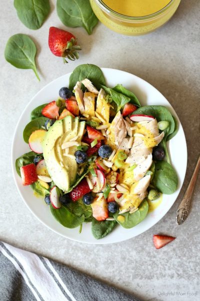 Super charge your day with this easy grilled chicken spinach salad topped with strawberries, blueberries, almonds, avocado and an anti-inflammatory turmeric almond salad dressing! #salad #spinachsaladrecipe #spinach #strawberries #blueberries #almonds #healthy #grilledchicken #maindish #healthy #dressing #turmeric | Recipe at delightfulmomfood.com