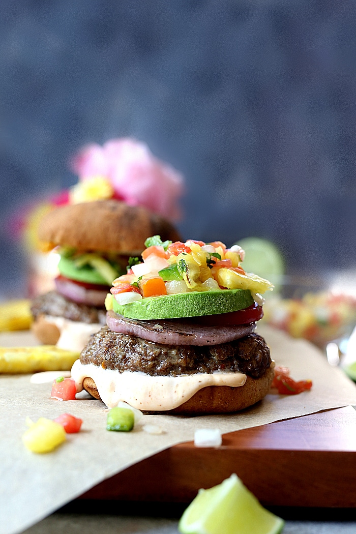 Easy grilled burgers with pineapple relish on top of a spicy aioli. Enjoy this juicy hamburger recipe at your next summer BBQ!