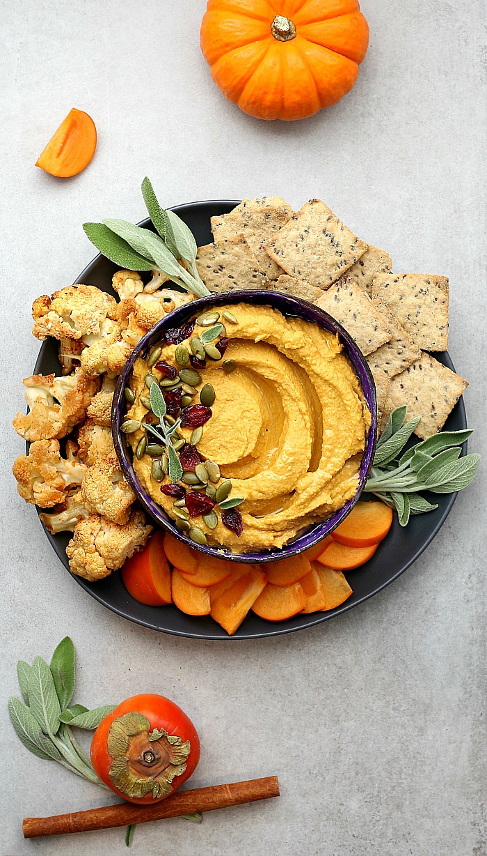 pumpkin hummus served with oil on top served with crackers and vegetables