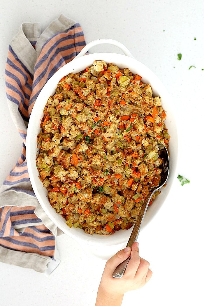 This gluten-free stuffing recipe is the BEST comfort food for the holidays! Gluten-free stuffing is simple to make with rich flavorful herbs, vegetables and gluten-free bread. It is plant-based and can be made vegan or stuffed in a turkey for meat lovers!  #glutenfree #stuffing #recipe #healthy #baked #Thanksgiving #Christmas #holiday #food | delightfulmomfood.com