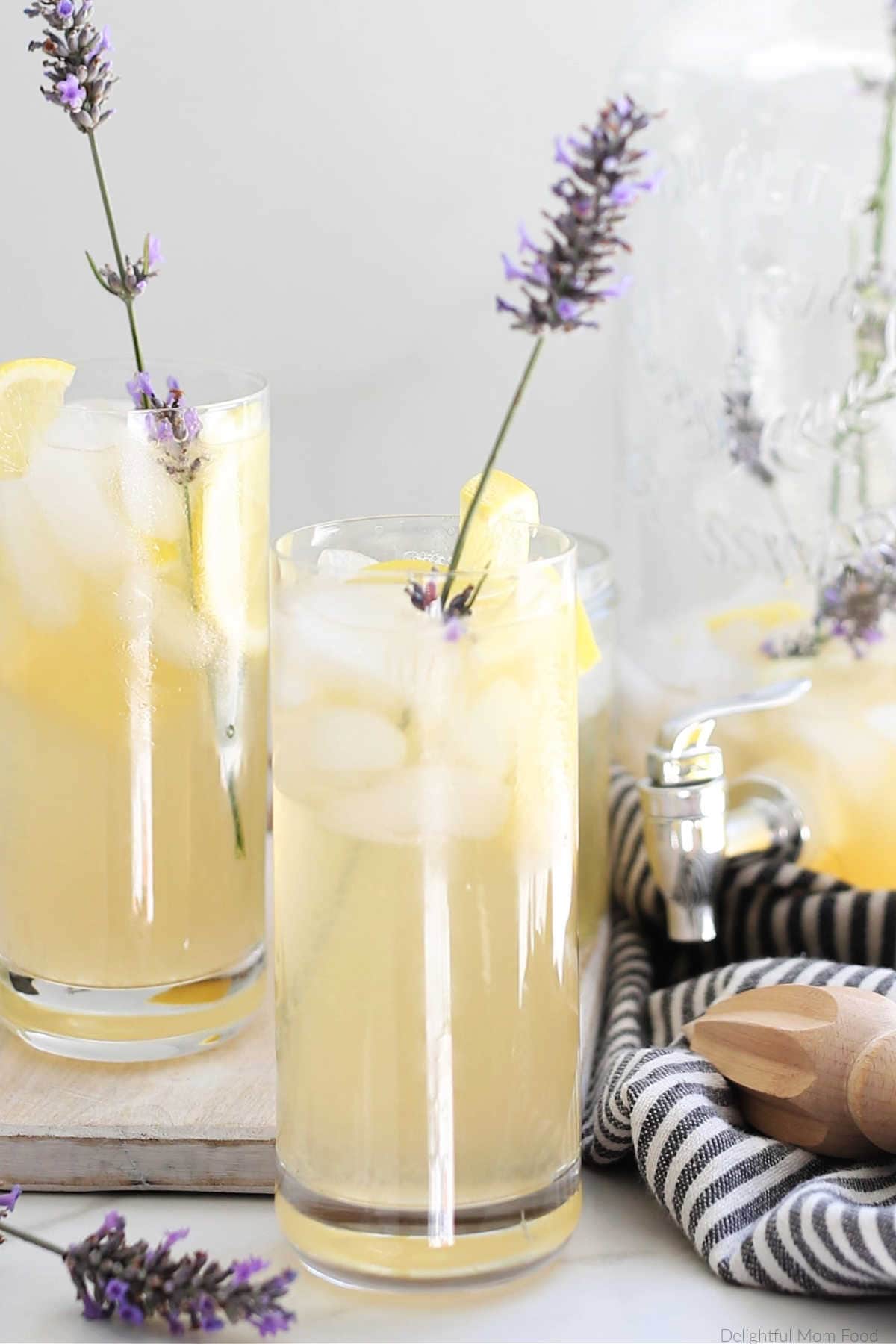 two glasses with lavender infused lemonade garnished with lavender stems and lemon slices