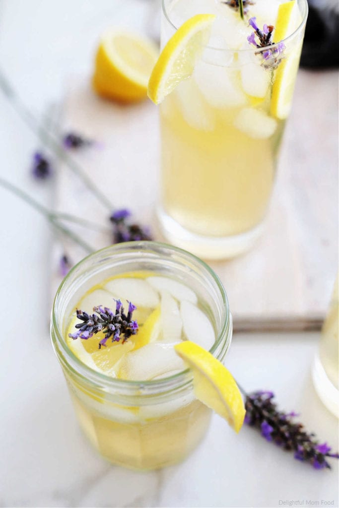 glass of homemade lavender lemonade, ice, Meyer lemon slice, and lavender stems