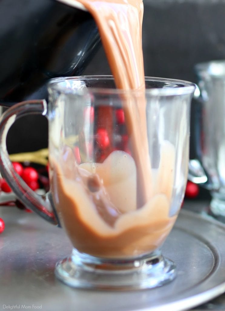 made from scratch vegan hot chocolate pouring from a pot into a clear glass mug