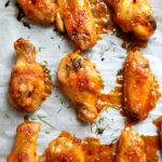 Get ready for the most tender gluten free sriracha chicken wings that fall off the bones! These baked party wings are dressed in a spicy sriracha sauce that will be the hit at the party! #sriracha #chicken #wings #party #superbowl #superbowlfood #tailgating #recipe #appetizer #glutenfree | Recipe at delightfulmomfood.com