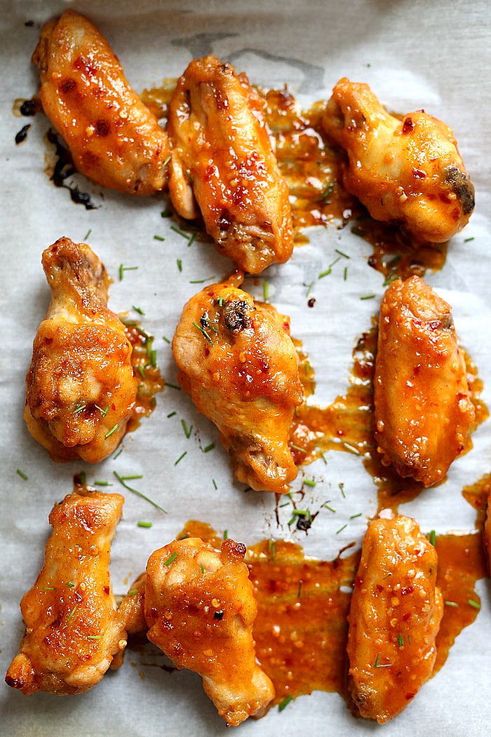 Get ready for the most tender gluten free sriracha chicken wings that fall off the bones! These baked party wings are dressed in a spicy sriracha sauce that will be the hit at the party! #sriracha #chicken #wings #party #superbowl #superbowlfood #tailgating #recipe #appetizer #glutenfree | Recipe at delightfulmomfood.com