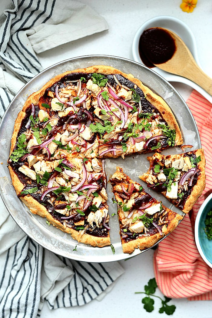 Barbecue Chicken Cauliflower Crust Pizza! How about a good pizza recipe without the bloated feeling after eating it?! 😊 This cauliflower crust BBQ chicken pizza is so flavorful, crispy, thin, light and your gut will thank you! It is packed with vegetables and protein and a copycat Trader Joe's cauliflower crust. delightfulmomfood.com #cauliflower #rice #pizza #glutenfree #crust #cauliflowerpizzacrust #healthy #dairyfree #barbecue #chicken #bbq #recipe