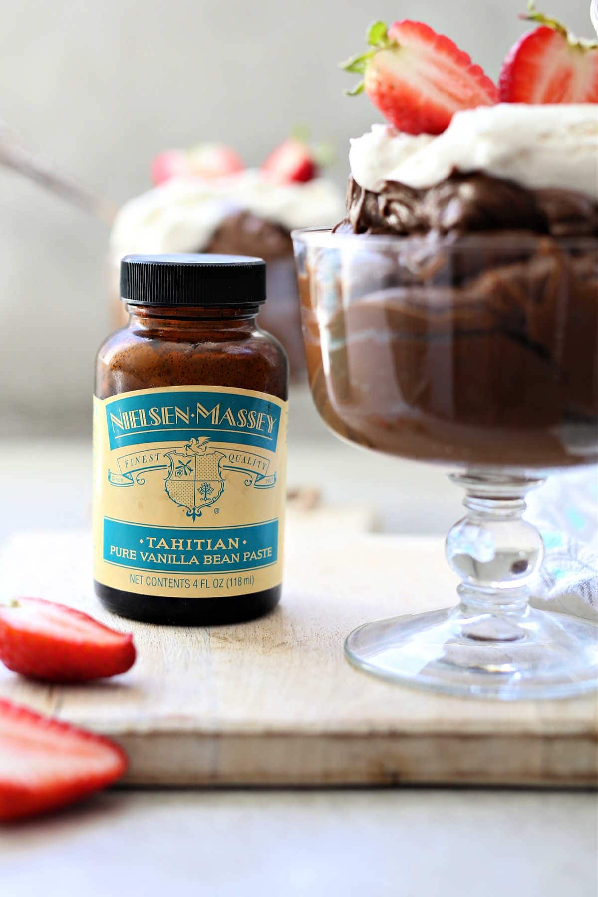 chocolate avocado pudding in a dessert cup with Nielsen-Massey vanilla paste bottle