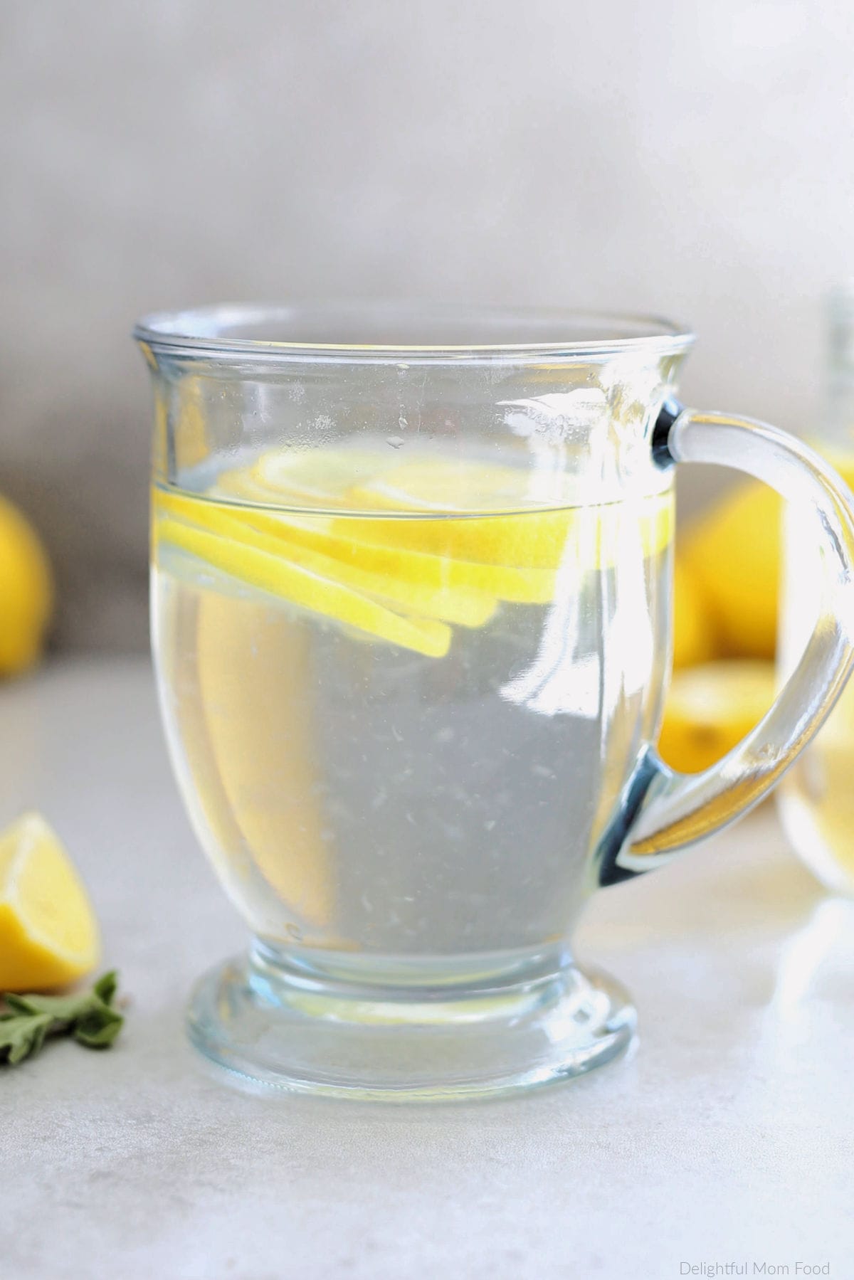 Mug with hot lemon water and citrus slices to absorb the benefits of lemon water.