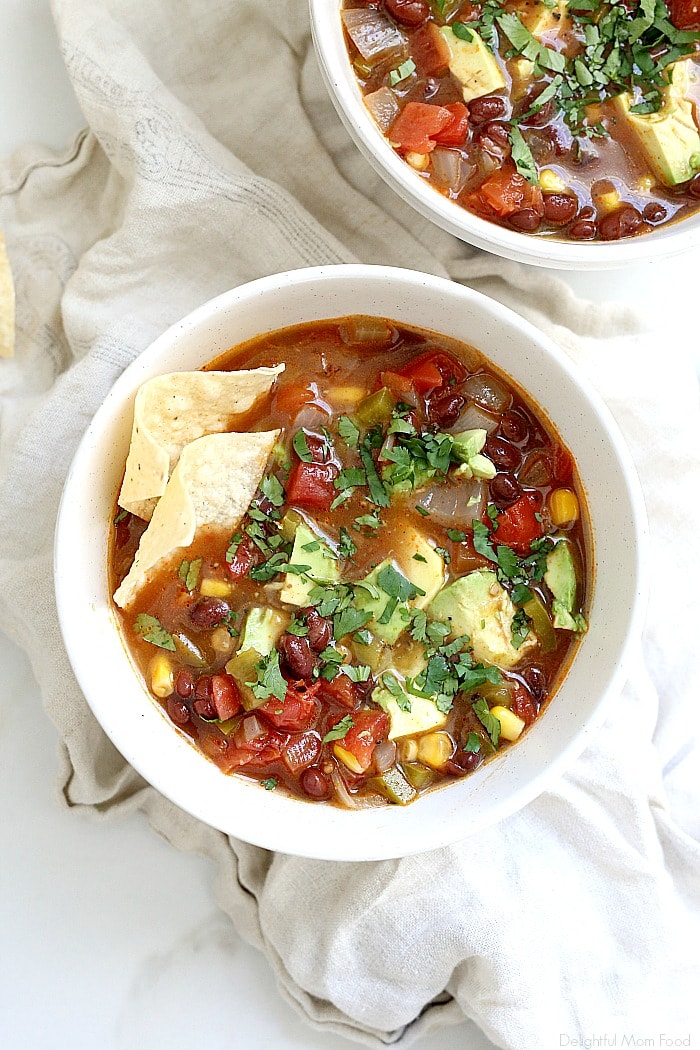 Healthy vegetarian tortilla soup full of savory Mexican vegetables. Chiles, sweet corn + spices add loads of flavor in this easy bean filled tortilla soup. Plus it is a healthy family meal ready in about 30 minutes! #vegetariantortillasoup #tortillasouprecipe #healthy #recipe #tortillasoup #glutenfree #dinner #soup #easytortillasoup | Recipe at Delightful Mom Food