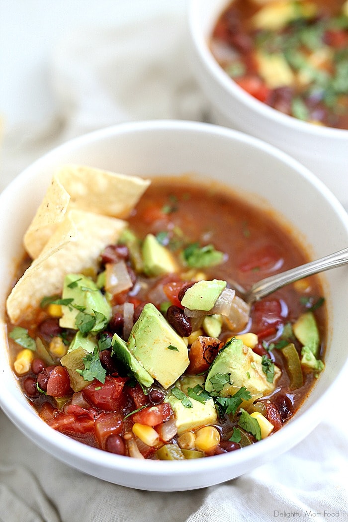 Healthy vegetarian tortilla soup full of savory Mexican vegetables. Chiles, sweet corn + spices add loads of flavor in this easy bean filled tortilla soup. Plus it is a healthy family meal ready in about 30 minutes! #vegetariantortillasoup #tortillasouprecipe #healthy #recipe #tortillasoup #glutenfree #dinner #soup #easytortillasoup | Recipe at Delightful Mom Food