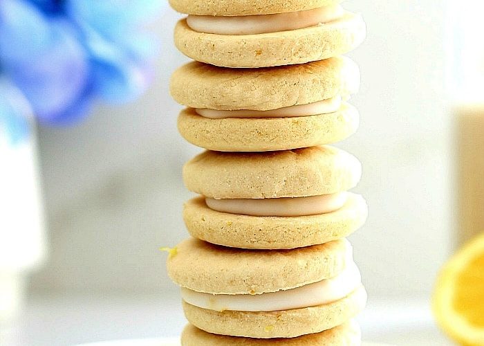 The perfect bright and cheery healthier cookies for spring! This soft lemon cookie recipe is vegan and gluten-free, turned into a sandwich filled with rich lemon icing that soaks into the cookies for a taste that tantalizes your taste buds! #softlemoncookierecipe #veganlemoncookies #lemoncookies #glutenfreelemoncookies #lemonfilledcookies #dessert #treats #easycookierecipe #healthycookierecipe | Recipe at Delightful Mom Food