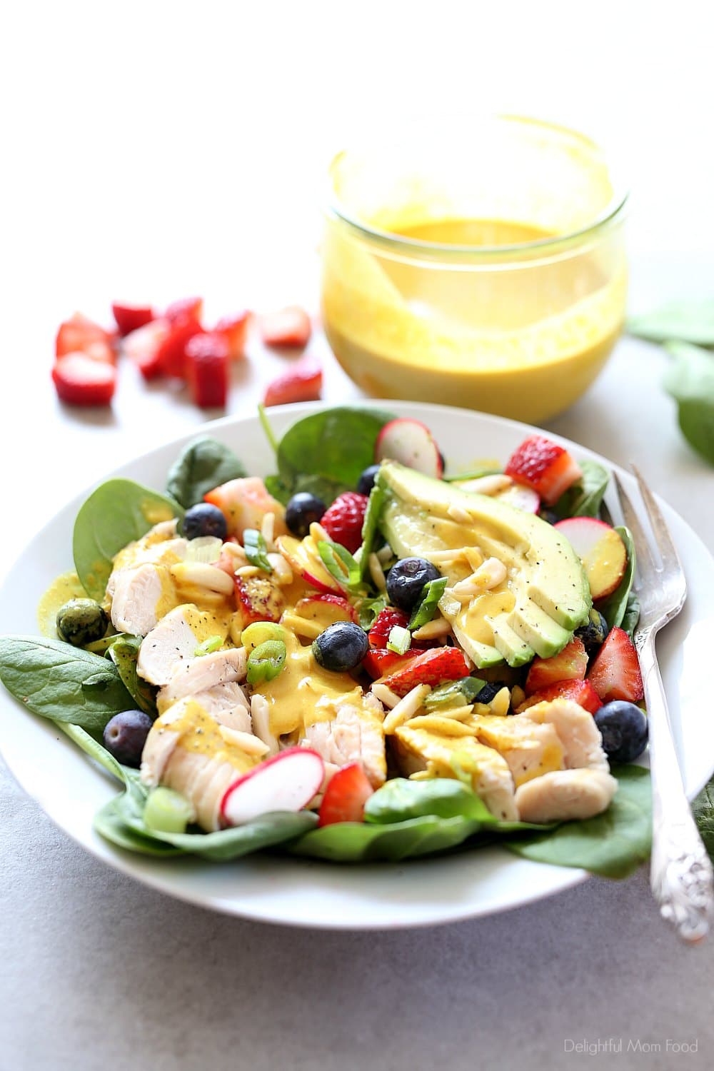 Super charge your day with this easy grilled chicken spinach salad topped with strawberries, blueberries, almonds, avocado and an anti-inflammatory turmeric almond salad dressing! #salad #spinachsaladrecipe #spinach #strawberries #blueberries #almonds #healthy #grilledchicken #maindish #healthy #dressing #turmeric | Recipe at delightfulmomfood.com