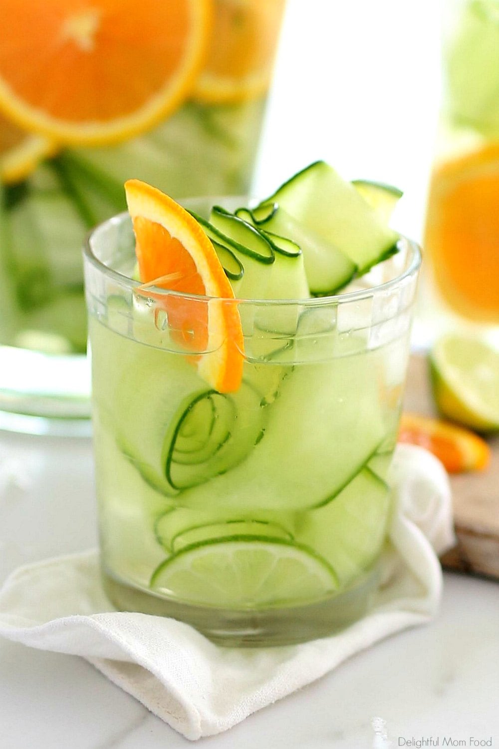 cucumber water in a glass with orange slices and mint