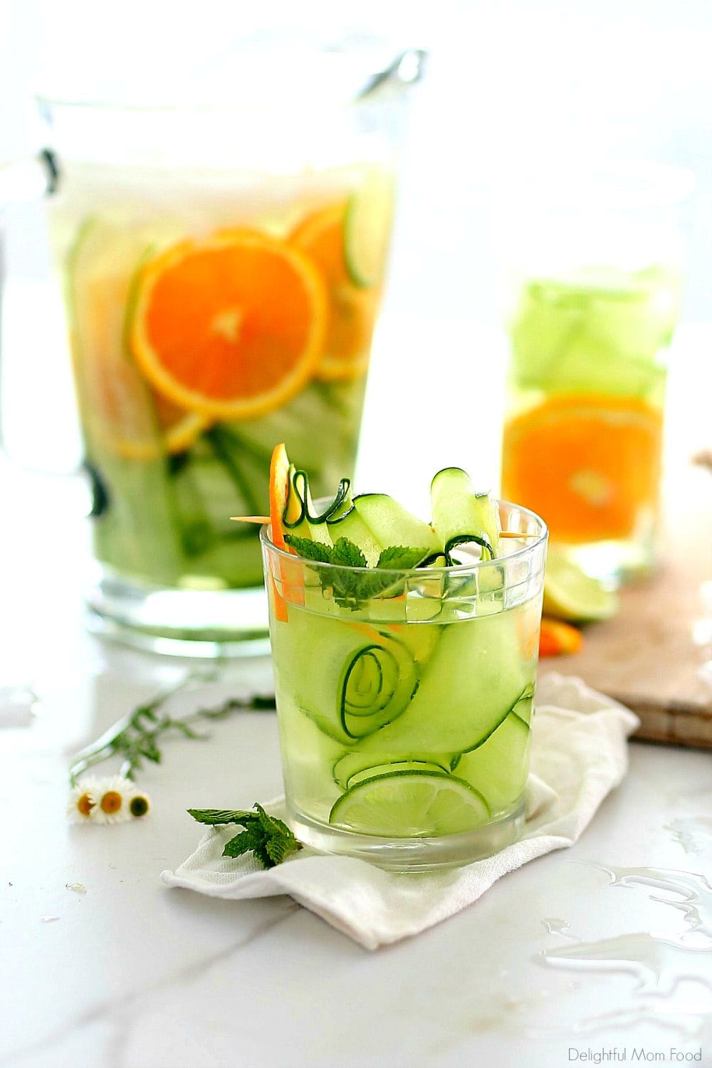 Enjoy this refreshing cucumber water recipe infused with fresh orange slices, mint and lime to increase hydration, absorption of immunity boosting vitamin C, and to achieve a vibrant complexion! It is easy to make and sip all day! #detox #water #recipe #cucumberwater #cucumberlimewater #orangecucumberwater #watercleanse #waterflush #cucumber #beverage #drink | Recipe at Delightful Mom Food