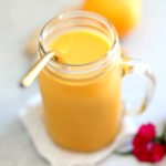 ginger and turmeric anti inflammatory smoothie recipe in a mason jar with a gold straw