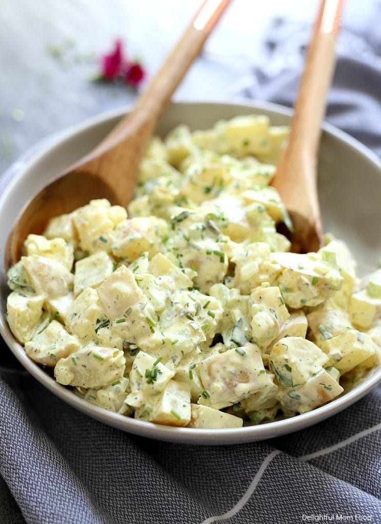 serving potato salad with wooden spoons off a platter