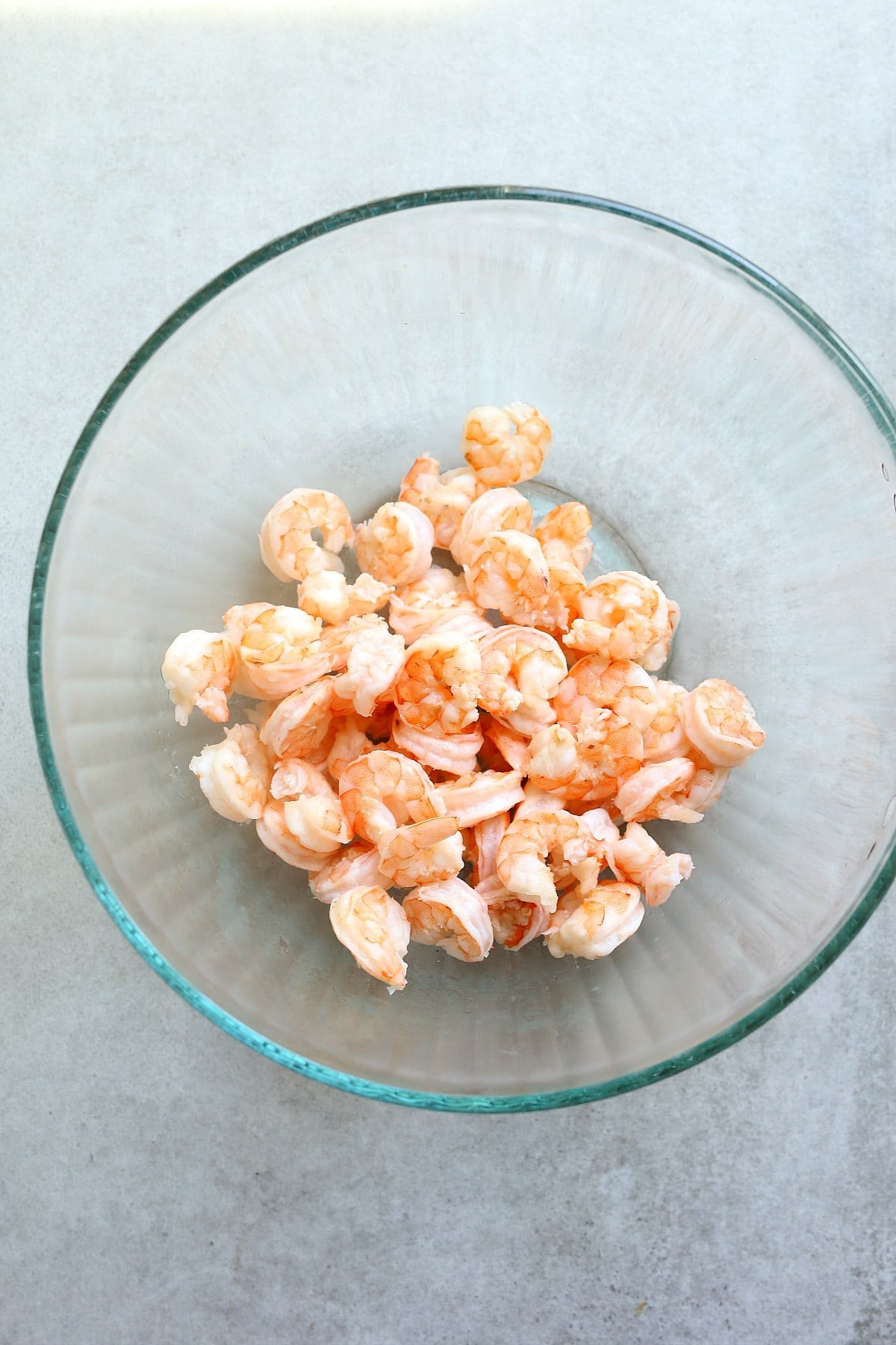 Boiled pink shrimp in a glass mixing bowl.
