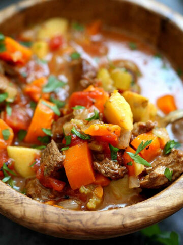 Instant pot beef stew recipe in a wood bowl.
