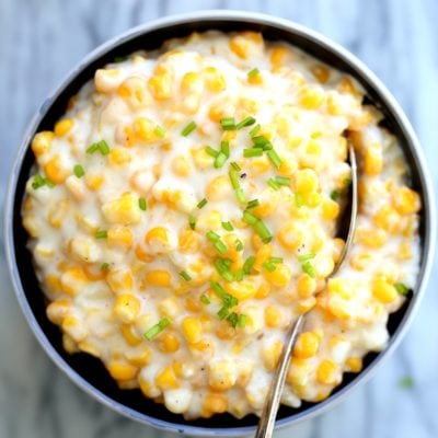 bowl of cream corn served with a spoon