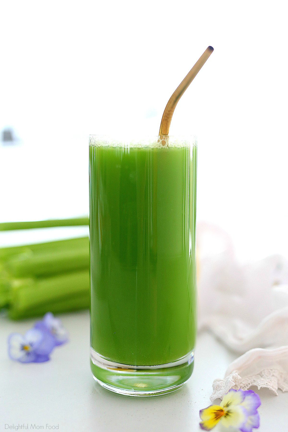 celery juice is a glass with a gold straw