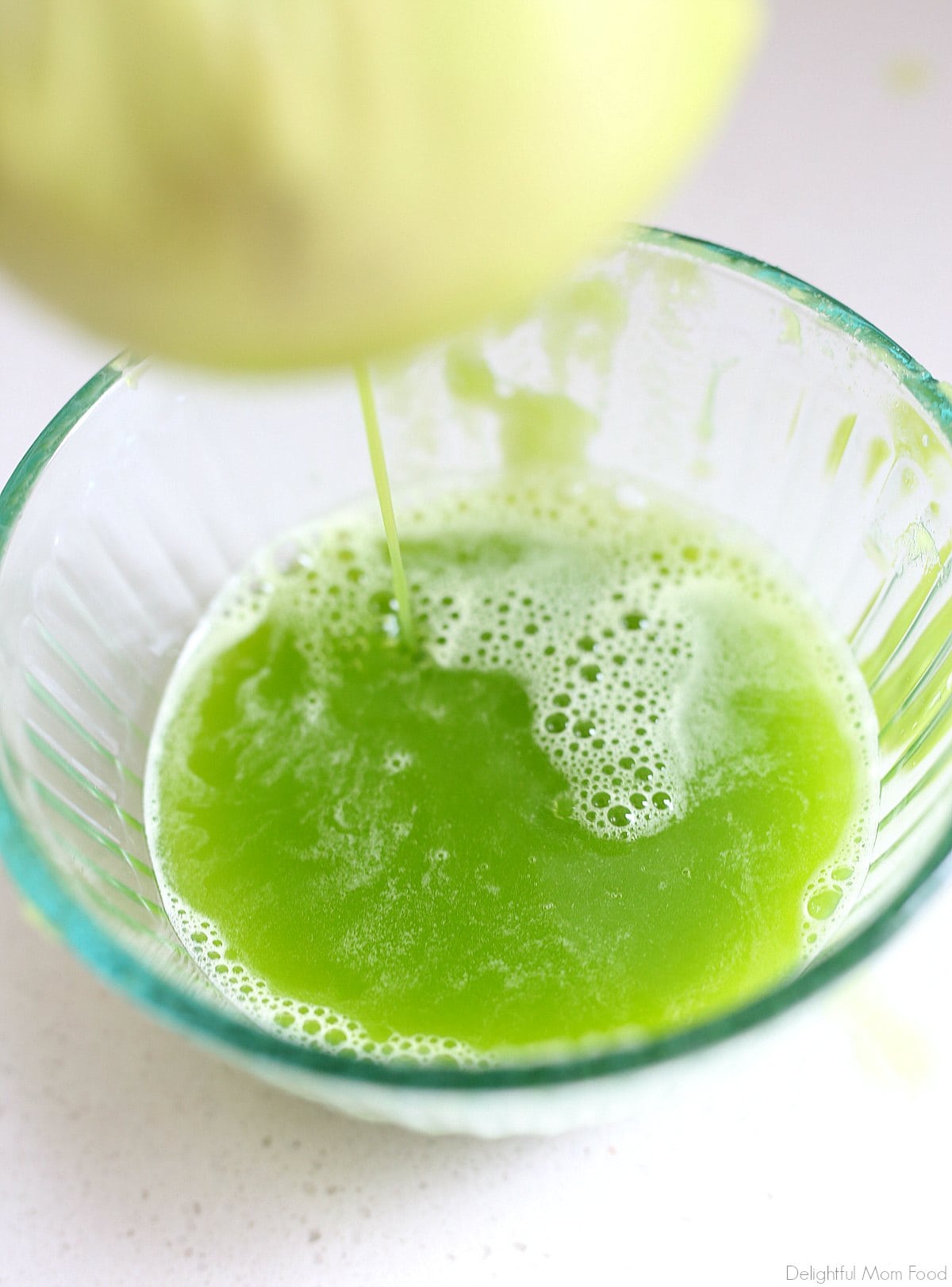 straining juice from blended celery into a bowl