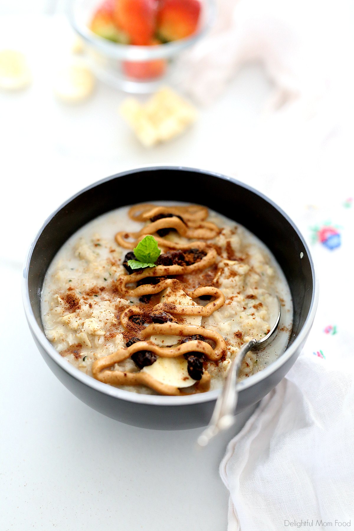 bowl of peanut butter oatmeal with banana slices, raisins and cinnamon