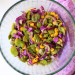 salad made of fava beans, corn, cabbage, onion in a glass bowl