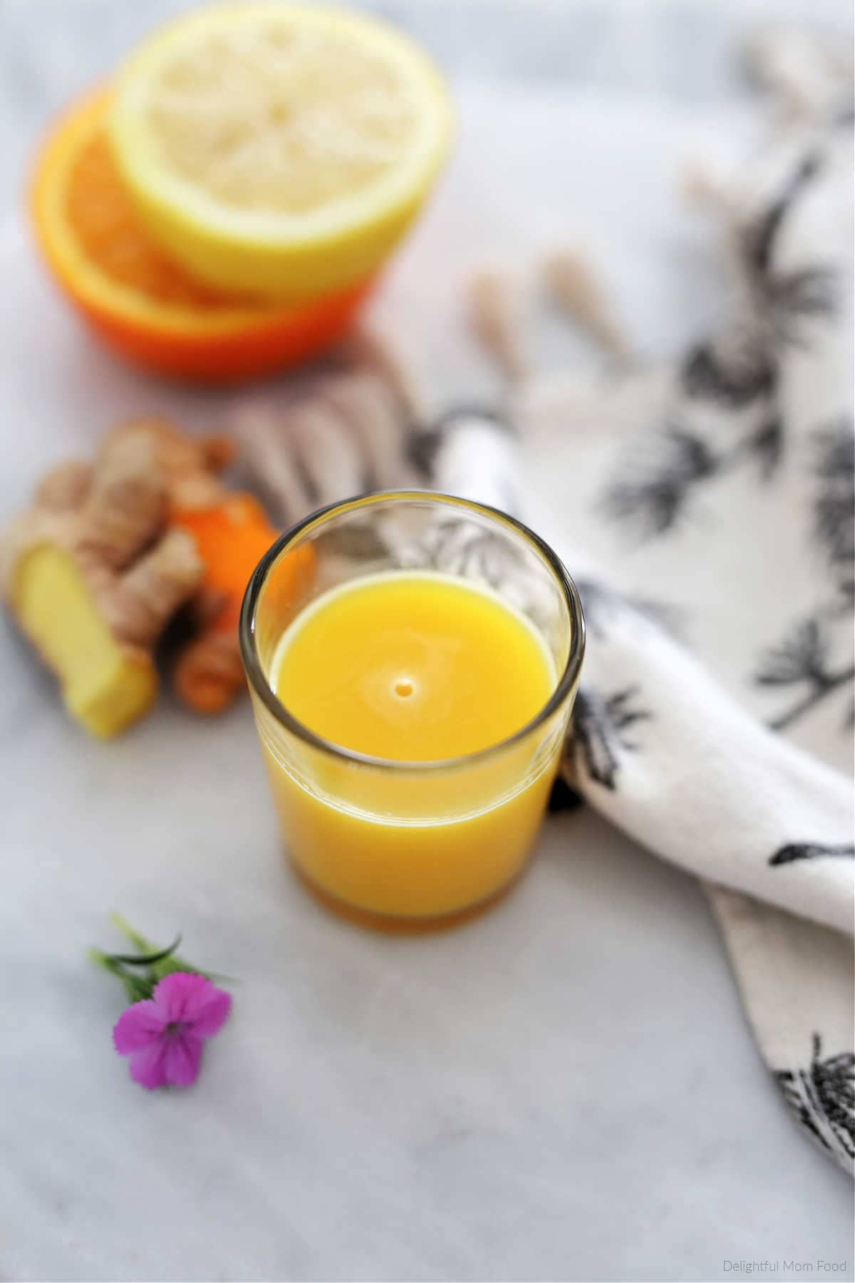 Ginger turmeric drink in a shot glass.