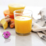 wellness ginger turmeric shot with lemon for cold in a shot glass