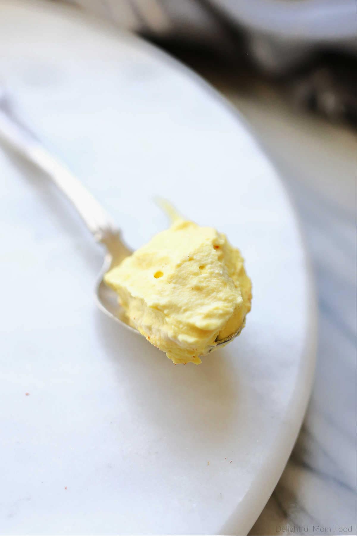Gourmet mustard deviled egg filling on a spoon.