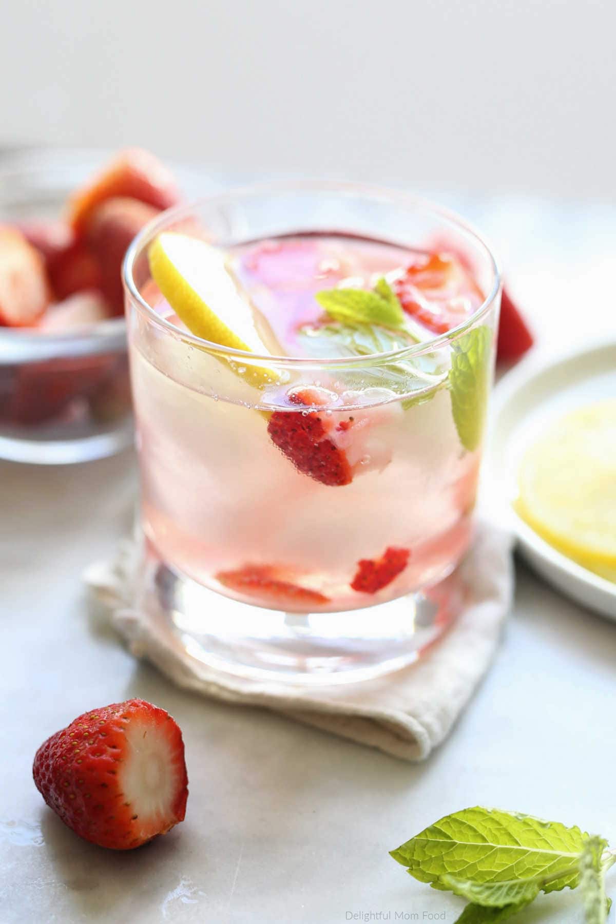 strawberry, lemon, mint infused into a detox water drink served in a glass