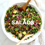 large bowl of a healthy kale detox salad with serving spoons